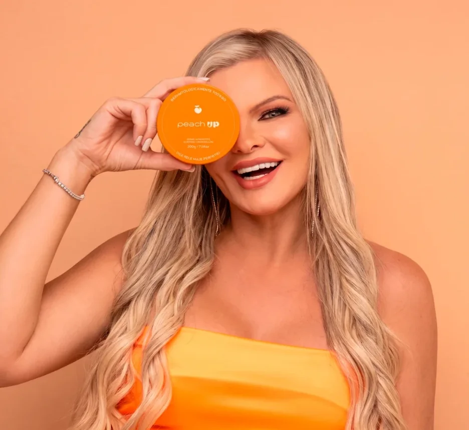 Lu Soares, fundadora da Peach Up, segurando o pote de Boomboom Up